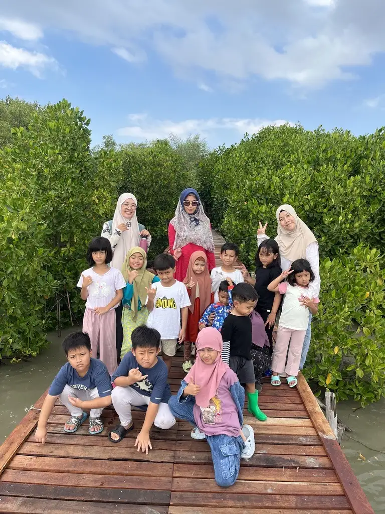 Anak-anak dan pendamping berfoto di jembatan pemantauan mangrove
