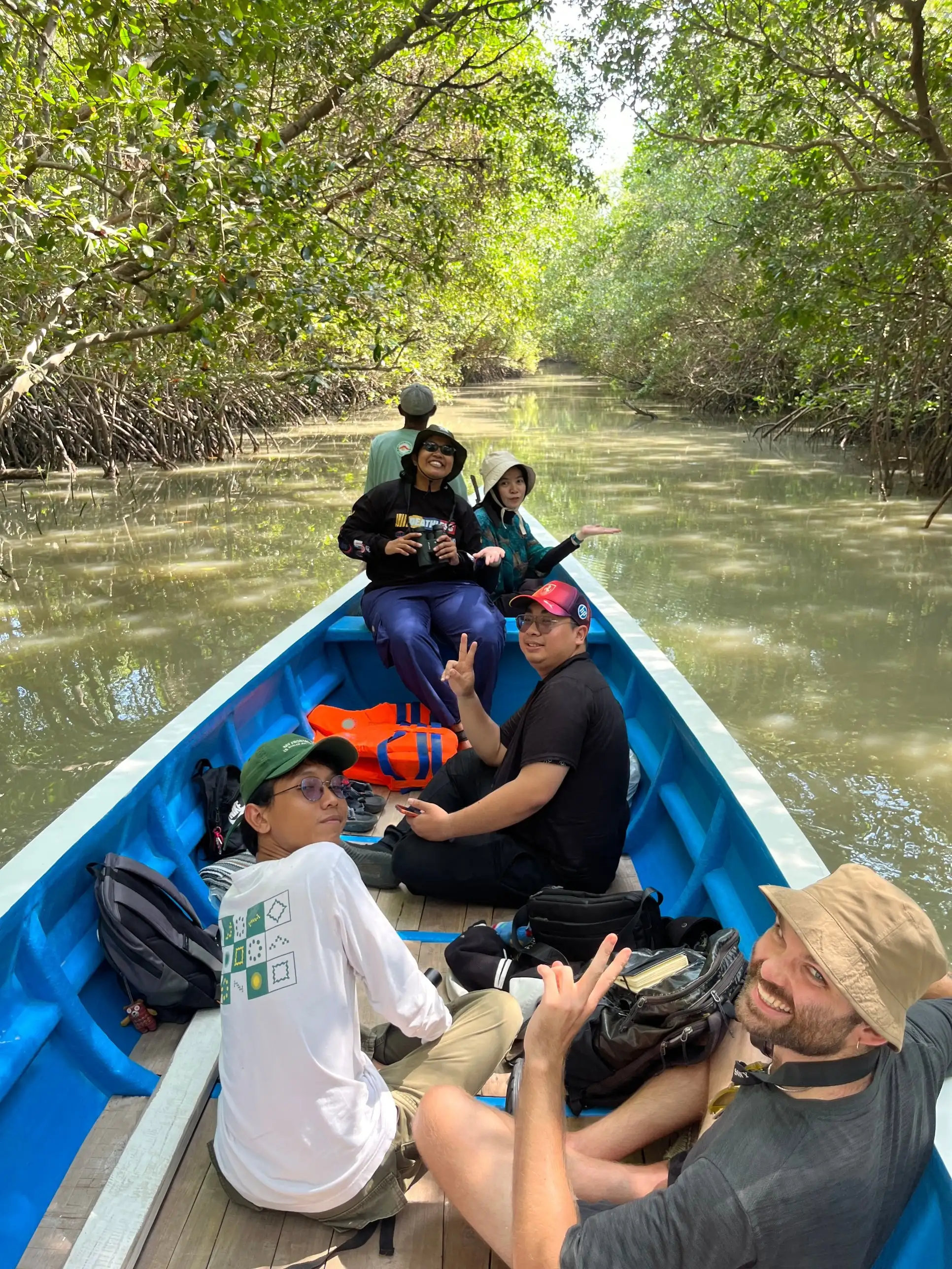 Peserta Mengare Discovery menyusuri alur sungai di bawah rimbun mangrove dengan perahu