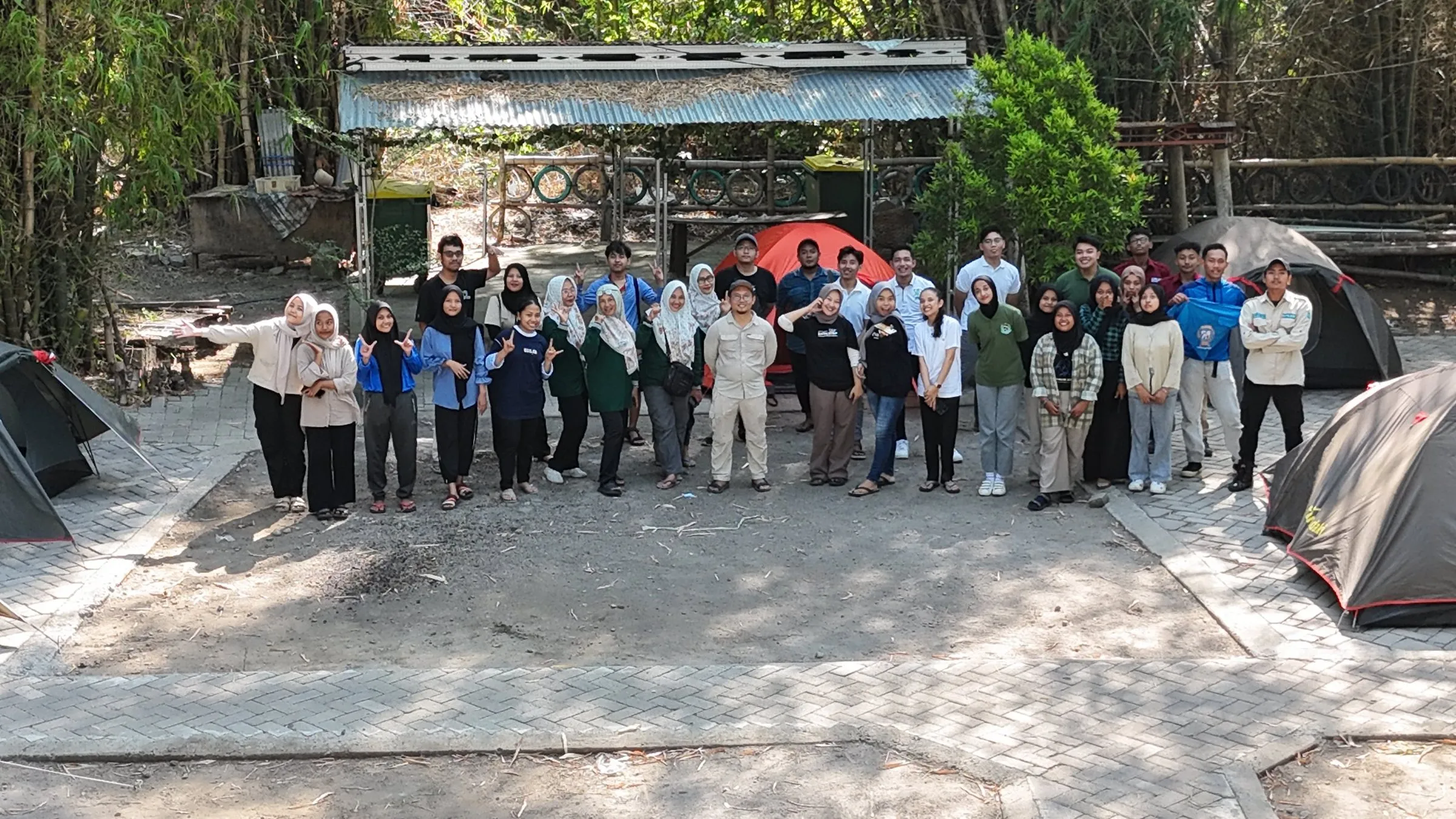 Peserta kemah berfoto bersama di area kemah di antara tenda
