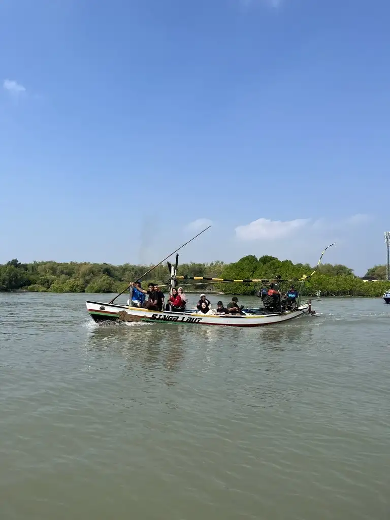 Perahu membawa rombongan menyusuri perairan pesisir