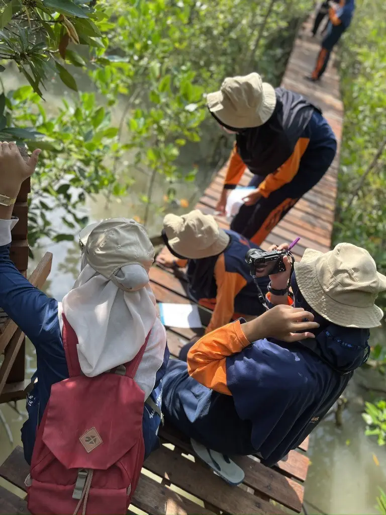Siswa memotret dan mencatat pengamatan dari jembatan pemantauan mangrove