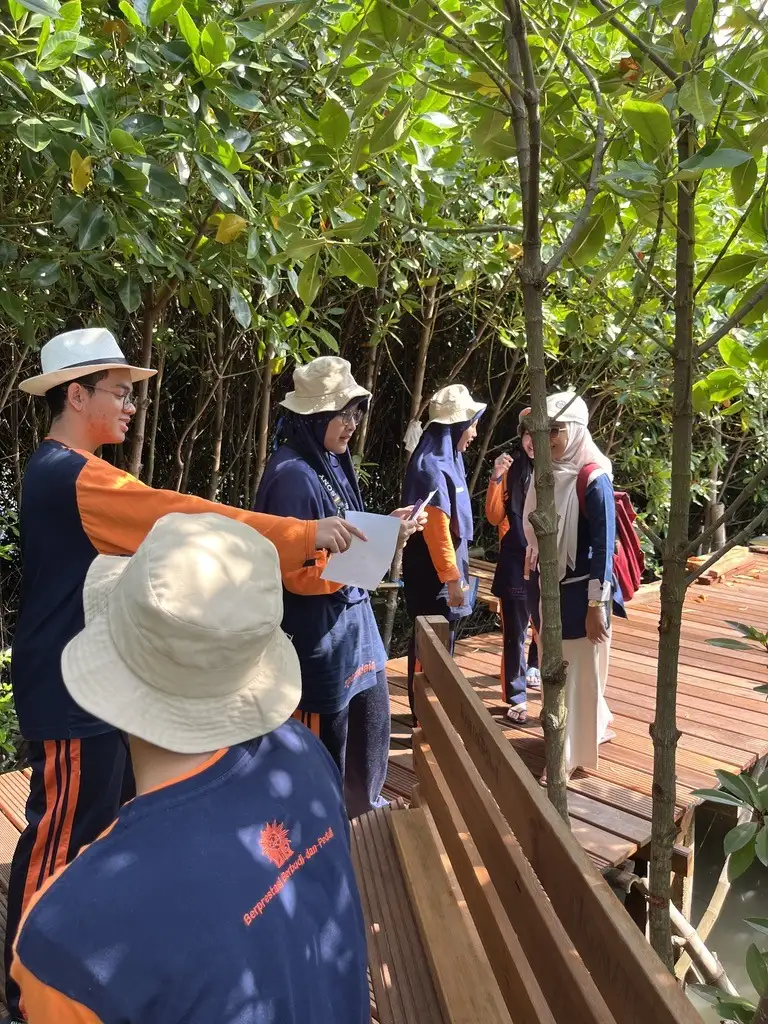 Siswa membawa lembar pengamatan di jembatan pemantauan mangrove