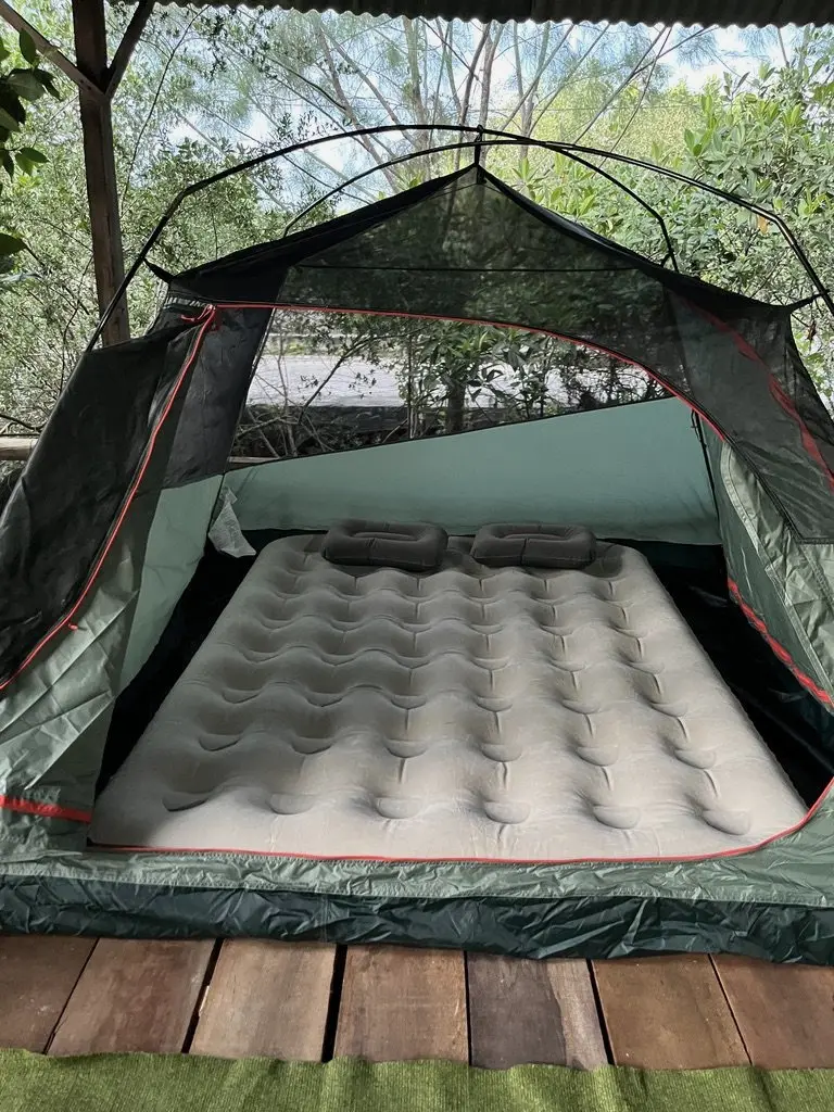 Tenda dengan kasur angin di area kemah