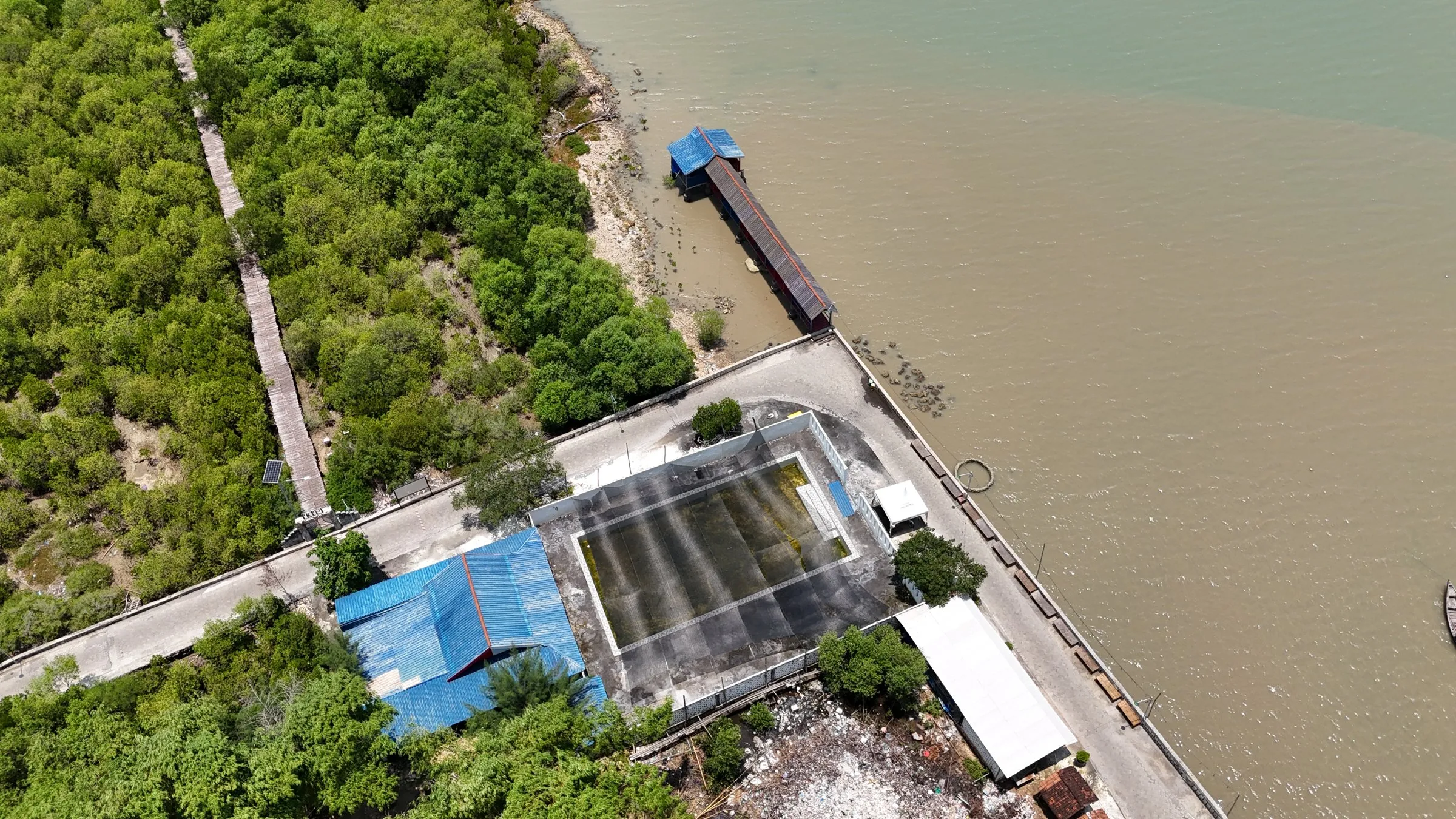 Foto udara bangunan PRPM Mengare, jembatan pemantauan mangrove, dan dermaga